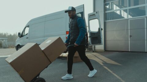 man pushing trolley with big boxes